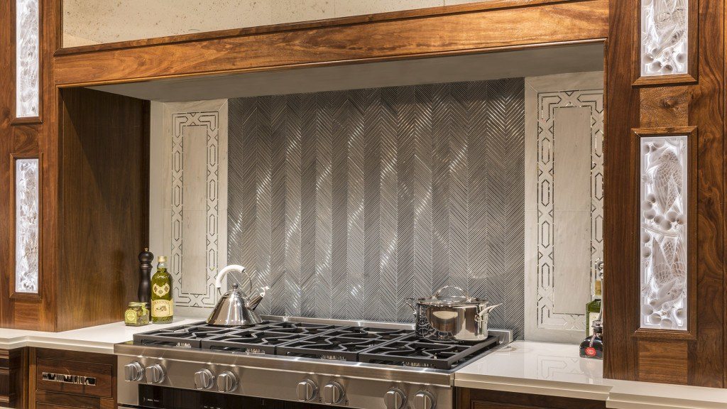 Textile Glass Mosaic in Silver Silk in the Ikat pattern creates a hearth effect. White Haze marble and an Allure radiance border complete the design.